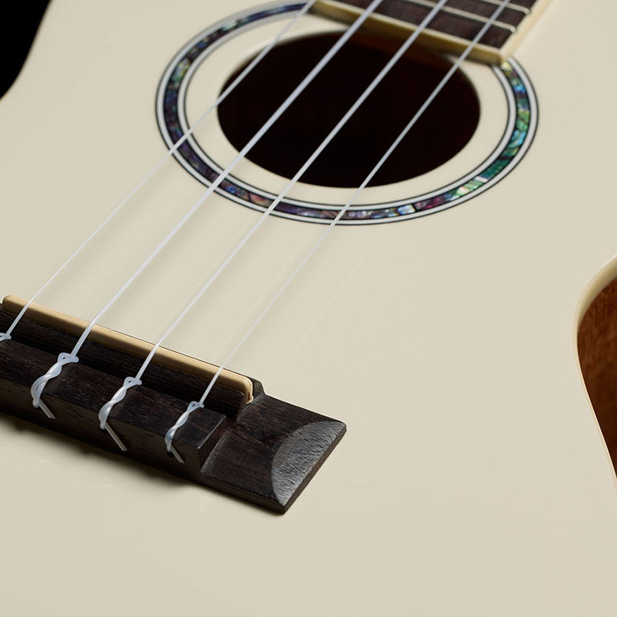 Close-up view of Córdoba 15C Mallorcan Pearl ukulele bridge thumb