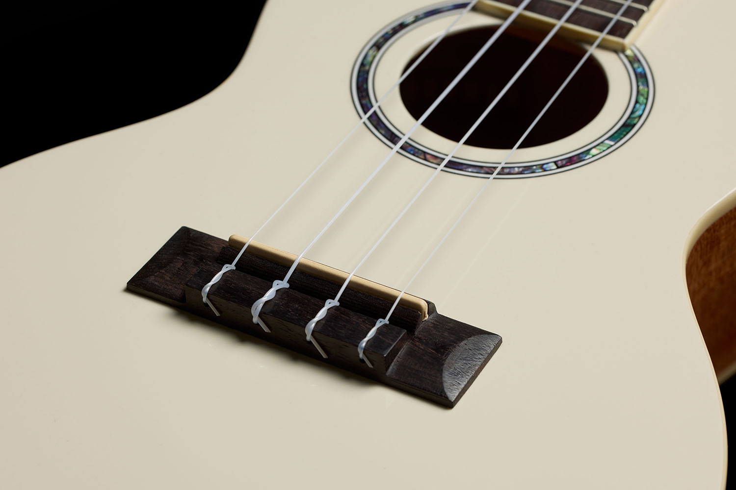 Close-up view of Córdoba 15C Mallorcan Pearl ukulele bridge