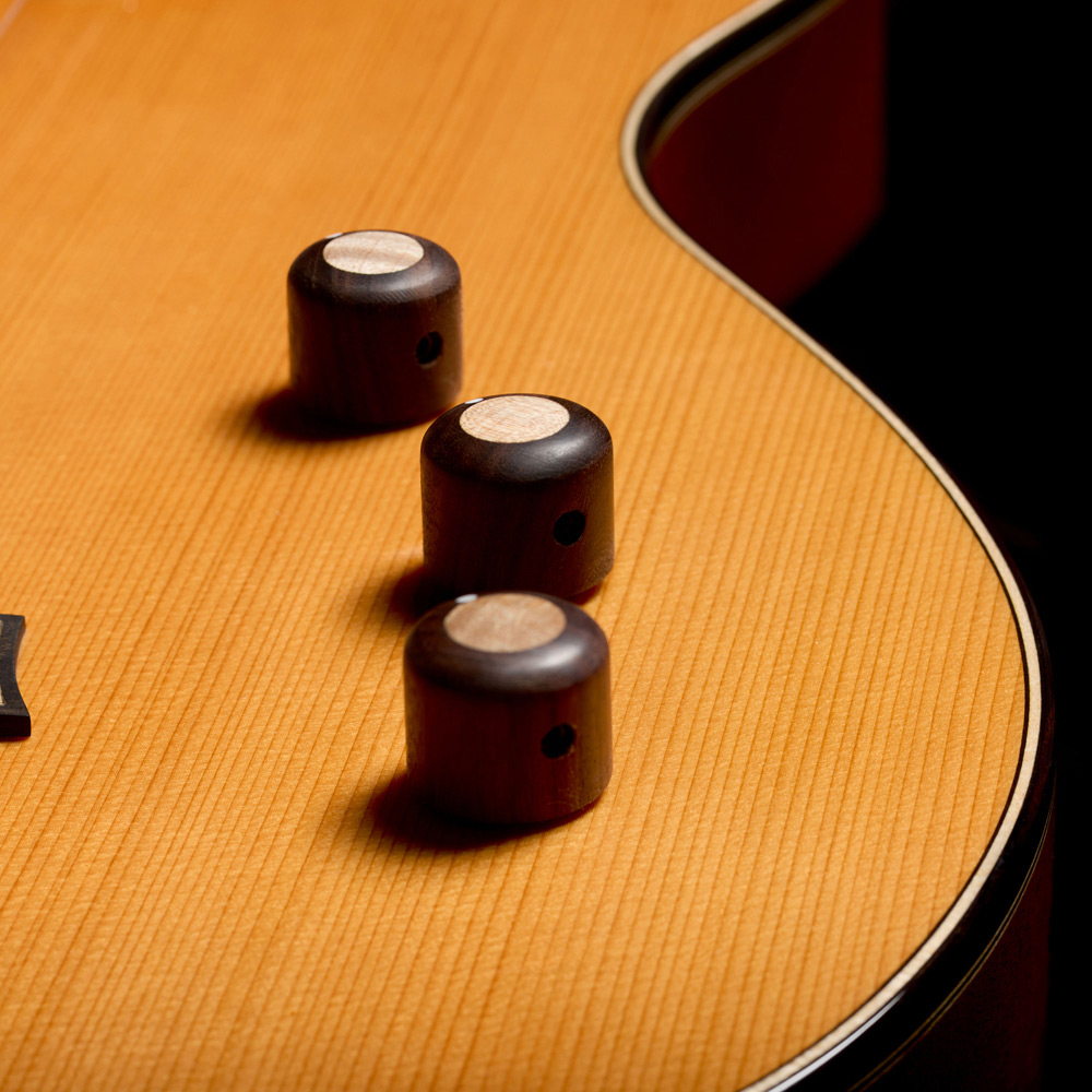Close-up view of Stage Artist Traditional rosewood knobs inlaid with maple thumb