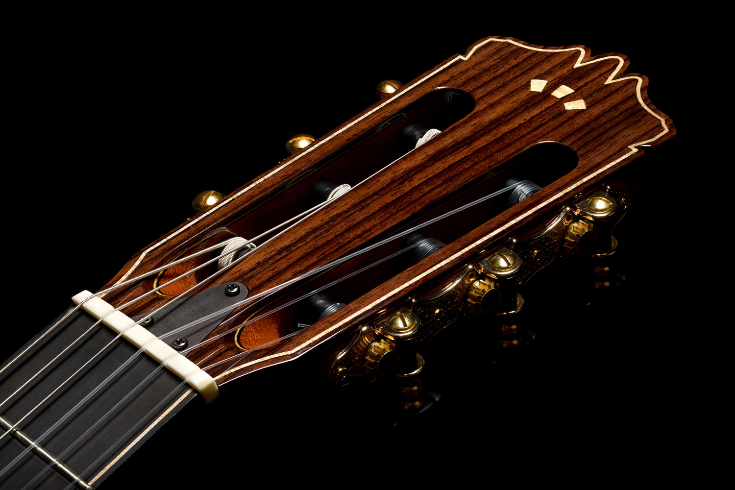 Close-up view of Stage Artist Traditional headstock featuring a flamed maple Córdoba Arches logo
