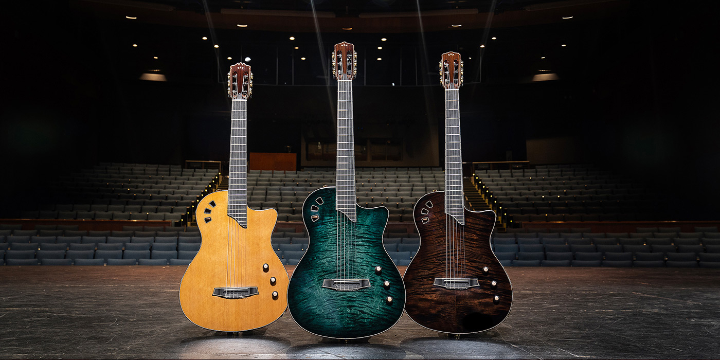 Three Stage Artist Guitars displayed on a stage with auditorium seats behind